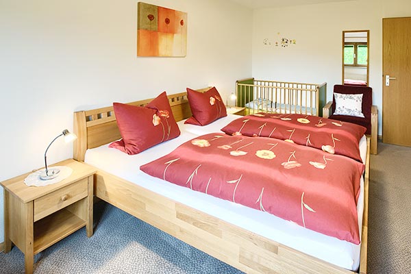 Schlafzimmer mit Doppelbett und Kinderbett