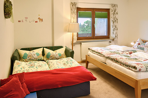 Schlafzimmer mit Doppelbett und Schlafcouch
