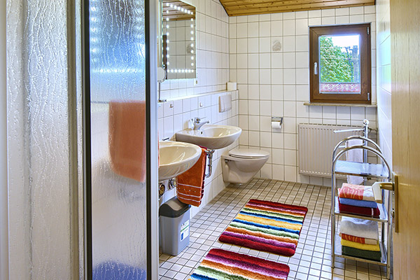 Bad mit Dusche, zwei Waschbecken und WC